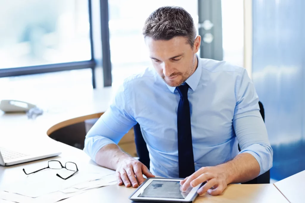 Hombre con una tablet haciendo una negociación con deudores reacios en DCL Gestión